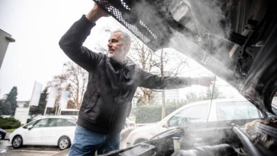 Steam Coming Out of Car Engine While Mature Man is Opening the Hood .
